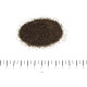 Haufen dunkles körniges Tierstreu auf weißem Hintergrund mit einem darunterliegenden Zentimeterlineal, beschriftet mit 'cm' und den Zahlen 0–6.