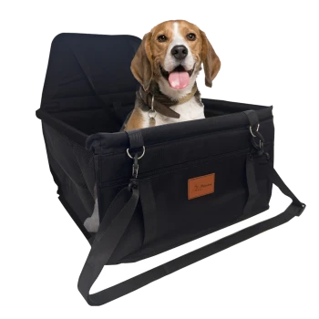 Ein Hund, der in einer schwarzen Haustiertrage mit gepolstertem Innenraum sitzt, mit einem Lederlogo-Patch und verstellbaren Riemen.