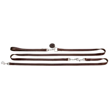 Braune Leder-Hundeleine mit silbernen Metallclips und einem runden Anhänger, flach auf einem weißen Hintergrund ausgelegt.