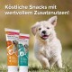 Un chiot heureux court sur l'herbe à côté des pâtes pour animaux Beaphar : Multi Vit Paste et Junior Paste, toutes deux favorisant des bienfaits pour la santé.