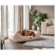 Hund mit rotem Fell schläft in einem beigen Cord-Hundebett mit Lederlabel „KNUFFELWUFF“ in einem gemütlichen Wohnzimmer.