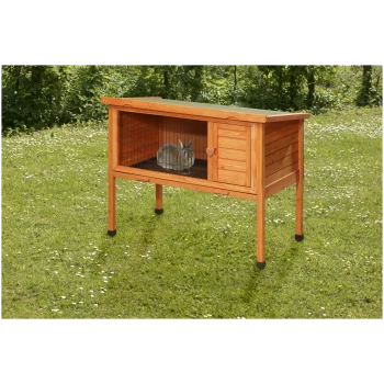 Une cabane en bois pour lapins avec un toit incliné, comportant une façade en treillis métallique et une petite porte, se trouve sur l'herbe avec un lapin à l'intérieur.