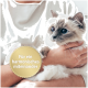 Weiß-graue langhaarige Katze mit blauen Augen, in den Armen gehalten, goldenes Siegel mit der Aufschrift 'Für ein harmonisches miteinander'.