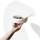 Eine Hand hält eine weiße Haustierfutterschüssel mit dem Text 'LIEBLINGSNAPF' und einem Löffel, gefüllt mit braunem Haustierfutter.