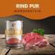 Eine Dose Wildfang Rind Pur Monoprotein-Hundefutter wird zusammen mit frischen Rindfleischstücken und Innereien auf einer Holzoberfläche präsentiert.