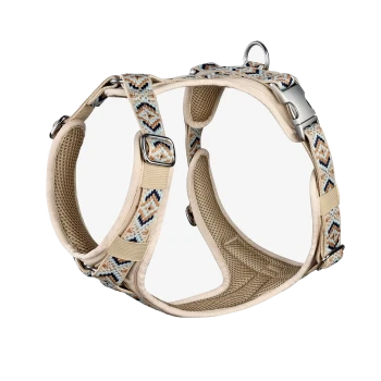 Beige Hundegeschirr mit einem bunten geometrischen Muster, mit verstellbaren Riemen und Metallverschlüssen, vor einem weißen Hintergrund präsentiert.