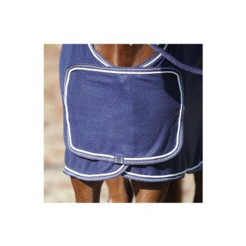 Eine Nahaufnahme eines Pferdes, das eine marineblaue Decke mit weißem Rand trägt, die die Taschendetails der Decke und die Beine des Pferdes zeigt.