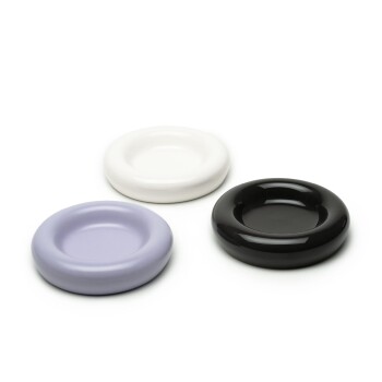 Drei Futternäpfe für Haustiere in Lavendel-, Weiß- und Schwarztönen, in einer Reihe auf einem weißen Hintergrund angeordnet.