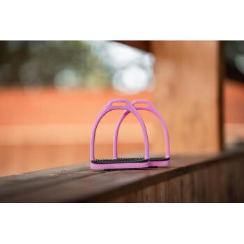 Rosa Pferdereitsteigbügel mit einer strukturierten schwarzen Basis, auf einer Holzoberfläche mit verschwommenem Hintergrund präsentiert.