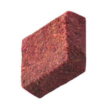 Ein rechteckiger Block Tierfutter, strukturiert und rötlich-braun, vor einem weißen Hintergrund präsentiert.