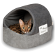 Ein gemütliches graues Katzenbett mit abgerundetem Oberteil und seitlichem Eingang, mit dem Text 'essen schlafen wiederholen' auf einem weißen Etikett.