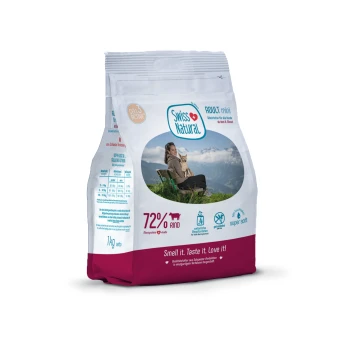 Sac de nourriture pour animaux de compagnie étiqueté "Swiss Natural" avec une photo d'une femme avec un chien, indiquant "72% Rind" et "Sentez-le. Goûtez-le. Aimez-le !"