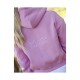 Eine Frau mit langen Haaren trägt einen rosa Kapuzenpullover mit dem gestickten Text 'SPOOKS EQUESTRIAN' auf dem Rücken.