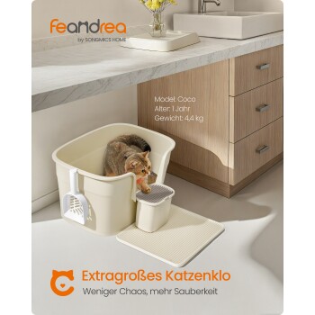Eine Katze in einer beigen Katzentoilette mit einer Schaufel und einer Matte darunter. Text: "Extragrößes Katzenklo - Weniger Chaos, mehr Sauberkeit."