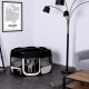 Ein schwarz-weißer Haustier-Spielbereich mit einem kleinen Hund in einem modernen Wohnzimmer mit einer Stehlampe, einer Amsterdam-Karte und einem Spielzeug auf dem Couchtisch.