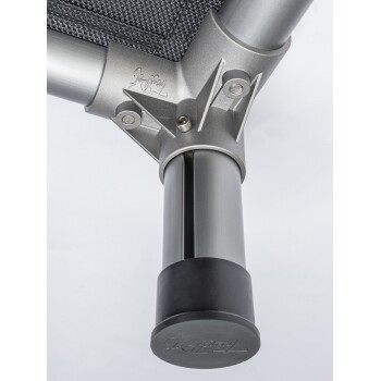 Nahaufnahme des Metallrahmens eines Haustierbettes, das ein stabiles silbernes Bein mit einem schwarzen Gummifuß und strukturiertem Stoff zeigt.