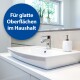 Modernes Badezimmerwaschbecken mit einem eleganten Wasserhahn, einem weißen Seifenspender und einem blauen Etikett mit der Aufschrift "Für glatte Oberflächen im Haushalt."
