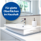 Modernes Badezimmerwaschbecken mit einem eleganten Wasserhahn, einem weißen Seifenspender und einem blauen Etikett mit der Aufschrift "Für glatte Oberflächen im Haushalt."
