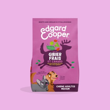 Sachet rose d'aliments pour chiens Edgard Cooper avec silhouette de cerf, deux chiens ; texte « GIBIER FRAIS ET CANARD » et « CHIENS ADULTES MEDIUM ».