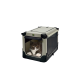 Eine flauschige schwarz-weiße Katze sitzt in einer beigen Haustiertragetasche mit Netzseiten und schaut neugierig aus der vorderen Öffnung.