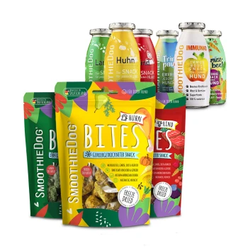 Bunte, gefriergetrocknete SmoothieDog-Hundesnacks: vorne gelbe 'BITES Huhn'-Tüte, rote 'Rind'-Tüten und verschiedene Flaschen mit Snacks, beschriftet 'IMMUNIO'.