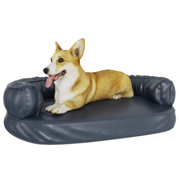 Ein glücklicher Corgi liegt auf einem plüschigen, marineblauen Hundebett mit runden Bolstern und zeigt Komfort und Entspannung.
