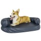 Ein glücklicher Corgi liegt auf einem plüschigen, marineblauen Hundebett mit runden Bolstern und zeigt Komfort und Entspannung.