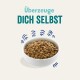 Schüssel mit Haustierfutter, gefüllt mit Kroketten, mit dem Text 'Überzeuge DICH SELBST' darüber, was auf die überzeugende Qualität hinweist.