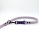 Eine lavendelfarbene Hundeleine mit einem schwarzen Clip und einem verstellbaren lila Abschnitt, mit schwarzen Löchern zur Größenanpassung.