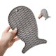 Eine Person hält eine graue Silikon-Futtermatte für Haustiere in Fischform, ausgestattet mit strukturierten Schuppen für besseren Halt.