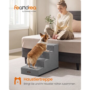 Corgi, der eine graue Haustiertreppe zum Bett hinaufsteigt, während eine Frau lächelt; sichtbarer Text 'feandrea' und 'Haustiertreppe'