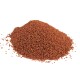 Ein Haufen feines, rötlich-braunes Haustierfutterpulver auf einem weißen Hintergrund, das seine körnige Textur zeigt.