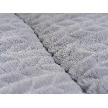 Nahaufnahme eines weichen, grauen Haustierbettes mit einem strukturierten, gesteppten Muster, das seinen plüschigen Stoff und das bequeme Design zeigt.