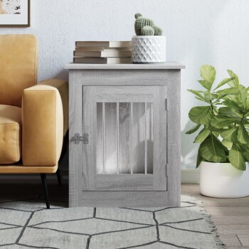 Grauer Holz-Haustierkäfig-Beistelltisch mit Riegel, Büchern und einem Kaktus oben, neben einem gelben Sofa und einer grünen Pflanze.