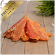 Premium-Haustierleckerei, die mehrere Stücke getrocknetes Fleisch auf einer Holzoberfläche zeigt, mit einem grünen Grasakzent im Hintergrund.