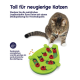Eine getigerte Katze spielt mit einem grünen Puzzlespielzeug mit Marienkäferstücken, das mentale und körperliche Stimulation fördert.