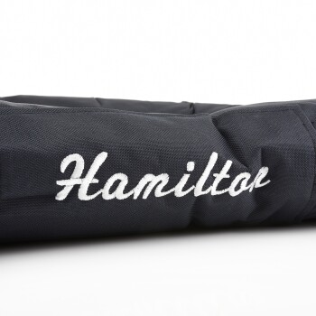 Nahaufnahme eines dunkelblauen Haustierbettes mit dem gestickten Namen "Hamilton" in weißer, geschwungener Schrift.