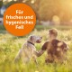 Eine Person sitzt auf einem sonnenbeschienenen Feld mit einem Labrador Retriever, begleitet von dem Text 'Für frisches und hygienisches Fell' in einem orangefarbenen Kreis.