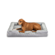 Ein brauner Hund liegt bequem auf einem plüschigen, grauen Haustierbett mit weichem Innenraum und gepolsterten Kanten.
