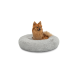 Ein flauschiger Pomeranian-Hund sitzt bequem in einem runden, weichen grauen Haustierbett auf einem weißen Hintergrund.