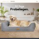 Ein Golden Retriever entspannt sich auf einem grauen Haustierbett in einem schicken Wohnzimmer, mit Text über eine 30-tägige Test- und Rückgabepolitik.