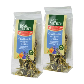 Deux paquets de bâtonnets de collation Real Nature pour petits animaux, contenant de la luzerne et des fleurs, avec des designs floraux colorés sur les étiquettes.