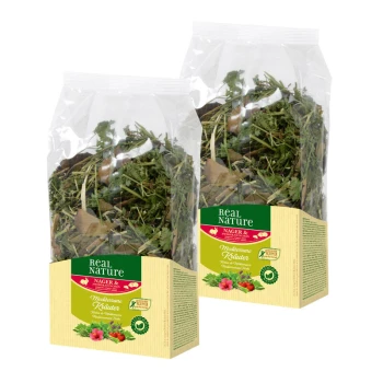 Deux sacs transparents d'herbes séchées étiquetés 'Real Nature' avec le texte 'Mediterrane Kräuter' sur un fond beige, avec des accents verts et rouges.