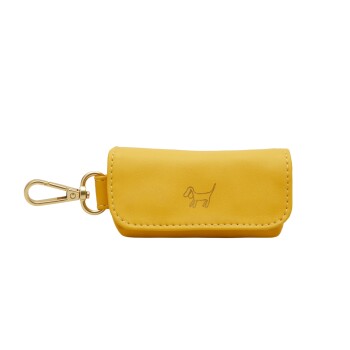Gelber Hundekotbeutelhalter mit einem goldenen Clip und einer einfachen Hundeskizze, die auf der Vorderseite eingeprägt ist.