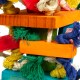 Buntes Haustierspielzeug aus Holzblöcken und natürlichen Fasern, das lebendige orange, rot, grün und blaue Elemente zeigt, die mit Seilen verflochten sind.
