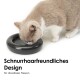 Eine hellgraue und weiße Katze frisst aus einer eleganten schwarzen Schüssel, mit dem Text "Schnurrhaarfreundliches Design für stressfreies Fressen" darunter.