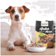 Die Vorderpfoten eines Hundes ruhen auf einer Holzoberfläche neben einer Schüssel mit Futter und einem Beutel mit der Aufschrift "proCani Huhn Komplett-Menü" mit Fleischbildern.