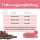 Trainingssnack für Hunde mit Huhn und Lachs, beschriftet mit "Wir wollen Meer Chicks," mit einem rosa Deckel und kleinen Leckerli-Stücken verstreut.