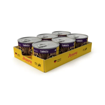 Acht Dosen Josera Tiernahrung, beschriftet mit "Truthahn", in einer gelben Box mit den Symbolen "Deutsche Qualität" und "Getreidefrei".