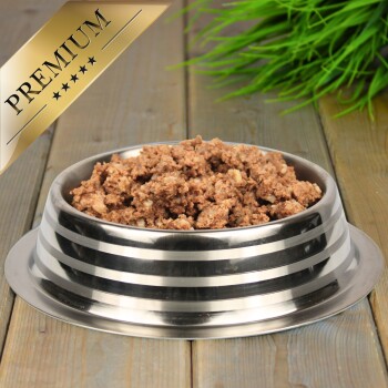 Eine Edelstahlschüssel für Haustierfutter, gefüllt mit hochwertigem Nassfutter für Hunde, mit einer strukturierten, fleischigen Mischung, mit einem goldenen "PREMIUM"-Etikett in der Ecke.